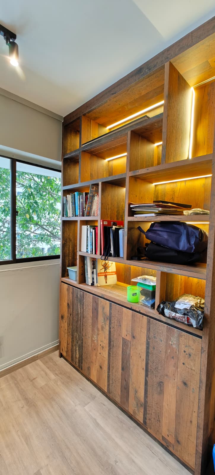 Rustic timber bookshelf detail with LED strip lighting and mixed storage compartments